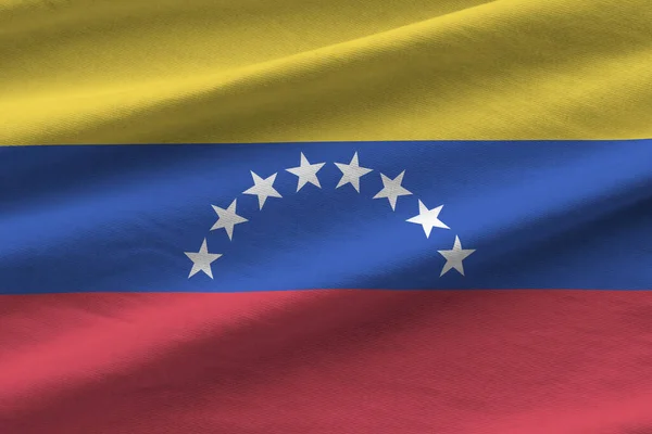 Venezuela flag with big folds waving close up under the studio light indoors. The official symbols and colors in fabric banner