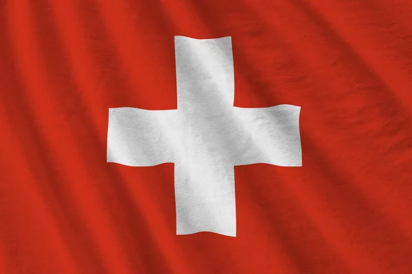 スタジオの照明の下で大きな折り目のあるスイスの旗が屋内で手を振っている ファブリックバナーの公式シンボルと色 — ストック写真