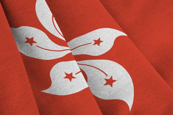 Hong kong flag with big folds waving close up under the studio light indoors. The official symbols and colors in fabric banner