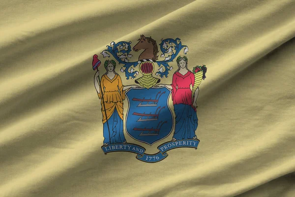 New Jersey eyalet bayrağı. Stüdyo ışıklarının altında büyük kıvrımlar sallanıyor. Resmi semboller ve renkler kumaş pankartıyla