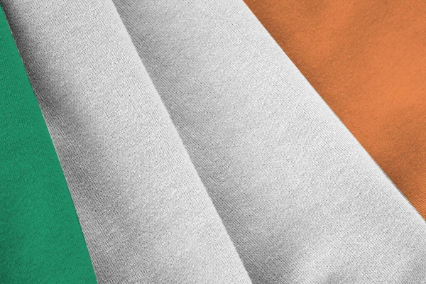 在室内的演播室灯光下 爱尔兰国旗飘扬着巨大的褶皱 织物横幅中的官方符号和颜色 — 图库照片