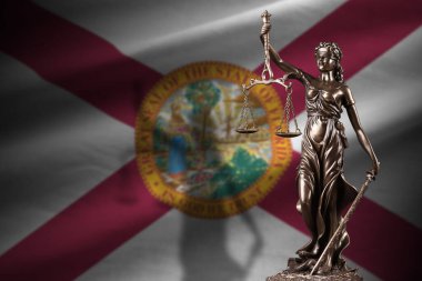 Florida eyalet bayrağı ve karanlık odada adalet heykeli ve adalet terazisi. Yargı ve ceza kavramı, jüri konuları için geçmiş