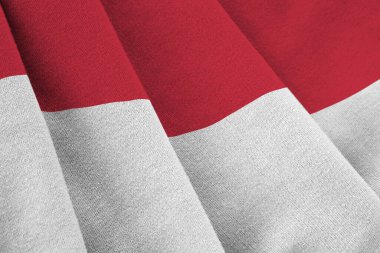 Büyük kıvrımlı Endonezya bayrağı stüdyo ışıklarının altında sallanıyor. Resmi semboller ve renkler kumaş pankartıyla