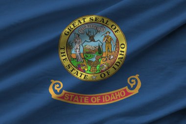 Idaho eyaleti bayrağı. Stüdyo ışıklarının altında büyük kıvrımlar sallanıyor. Resmi semboller ve renkler kumaş pankartıyla