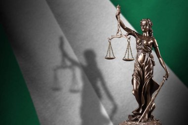 Nijerya bayrağı ve karanlık odada adalet heykeli ve yargı terazisi. Yargı ve ceza kavramı, jüri konuları için geçmiş