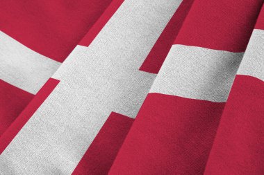 Büyük kıvrımlı Danimarka bayrağı stüdyo ışıklarının altında sallanıyor. Resmi semboller ve renkler kumaş pankartıyla