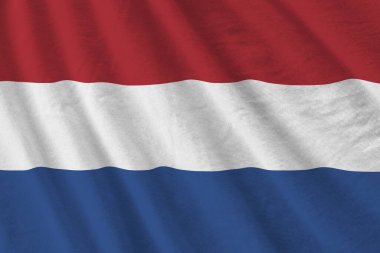 Büyük kıvrımlı Hollanda bayrağı stüdyo ışıklarının altında sallanıyor. Resmi semboller ve renkler kumaş pankartıyla