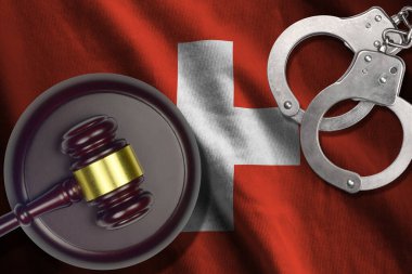 Karanlık odada yargıç tokmağı ve kelepçeli İsviçre bayrağı. Suç ve ceza kavramı, suçlu konular için geçmiş