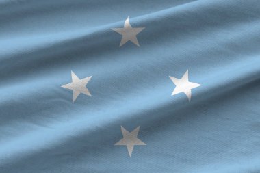 Büyük kıvrımlı mikronezya bayrağı stüdyo ışıklarının altında sallanıyor. Resmi semboller ve renkler kumaş pankartıyla