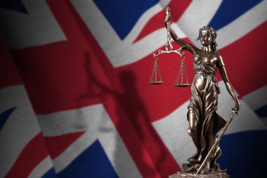 Great britain flag with statue of lady justice and judicial scales in dark room. Concept of judgement and punishment, background for jury topics clipart