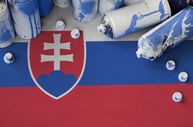 Slovakya bayrağı ve birkaç kullanılmış sprey boya kutusu. Sokak sanatı kültürü kavramı, vandalizm sorunları