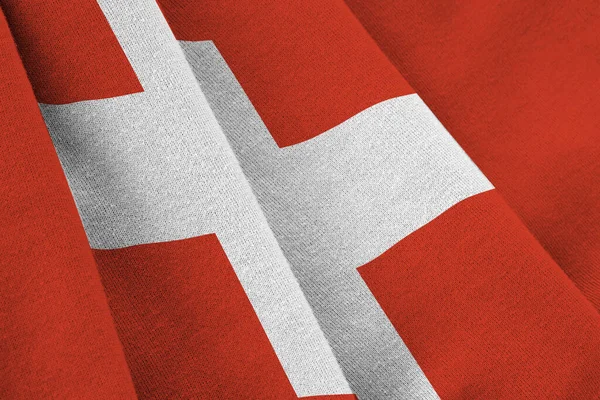 スタジオの照明の下で大きな折り目のあるスイスの旗が屋内で手を振っている ファブリックバナーの公式シンボルと色 — ストック写真