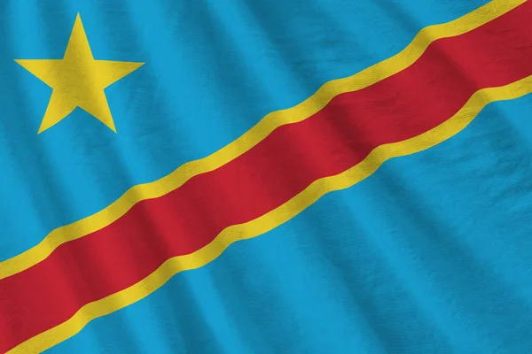 在室内的演播室灯光下 巨大的褶皱摇曳着刚果民主共和国的国旗 织物横幅中的官方符号和颜色 — 图库照片