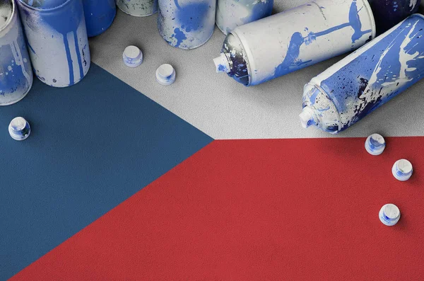 Czech flag and few used aerosol spray cans for graffiti painting. Street art culture concept, vandalism problems