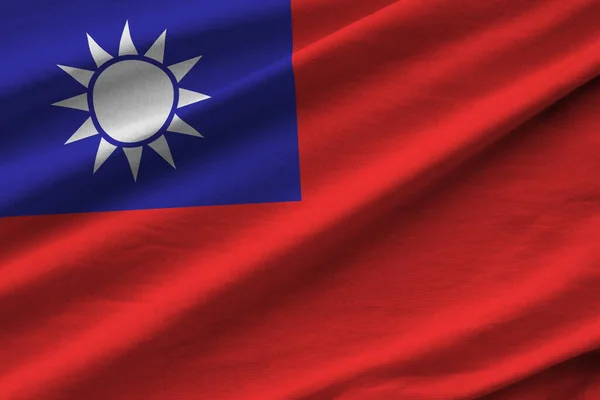 Taiwan flag with big folds waving close up under the studio light indoors. The official symbols and colors in fabric banner