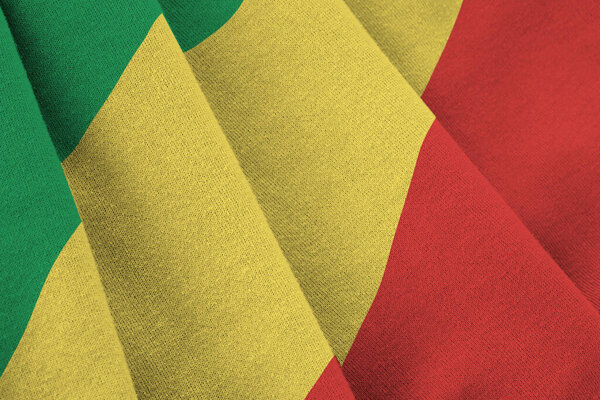 Congo flag with big folds waving close up under the studio light indoors. The official symbols and colors in fabric banner