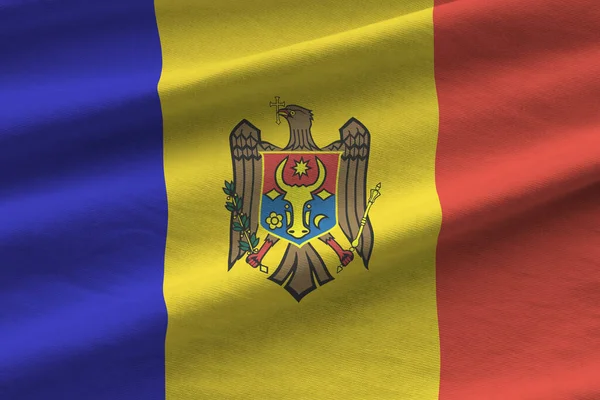 Büyük kıvrımlı Moldova bayrağı stüdyo ışıklarının altında sallanıyor. Resmi semboller ve renkler kumaş pankartıyla