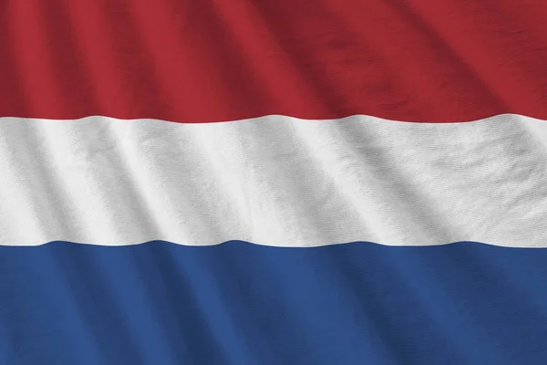 荷兰国旗与巨大的折叠挥动紧密在工作室的灯光下室内 织物横幅中的官方符号和颜色 — 图库照片