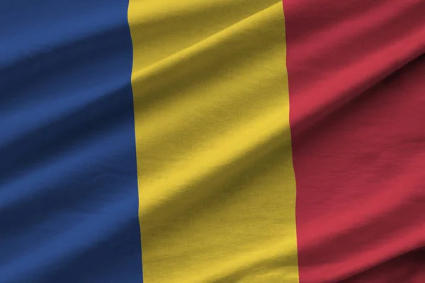 在室内的工作室灯光下 罗马尼亚国旗飘扬着巨大的褶皱 织物横幅中的官方符号和颜色 — 图库照片