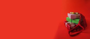 Noel ve yeni yıl hediyeleriyle fotokopi odası olan kırmızı pankart. Kırmızı pankartta bayram hediyeleri, kopyalama alanı, negatif boşluk