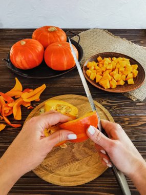 Portakal kabağı çorbası servis masasında beyaz bir tabakta peçetede öğle yemeği, akşam yemeği, siyah ekmek, yeşil maydanoz beyaz tabakta, ahşap kahverengi masa