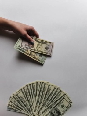 Beyaz arka plandaki bir kızın ellerinde Amerikan doları.