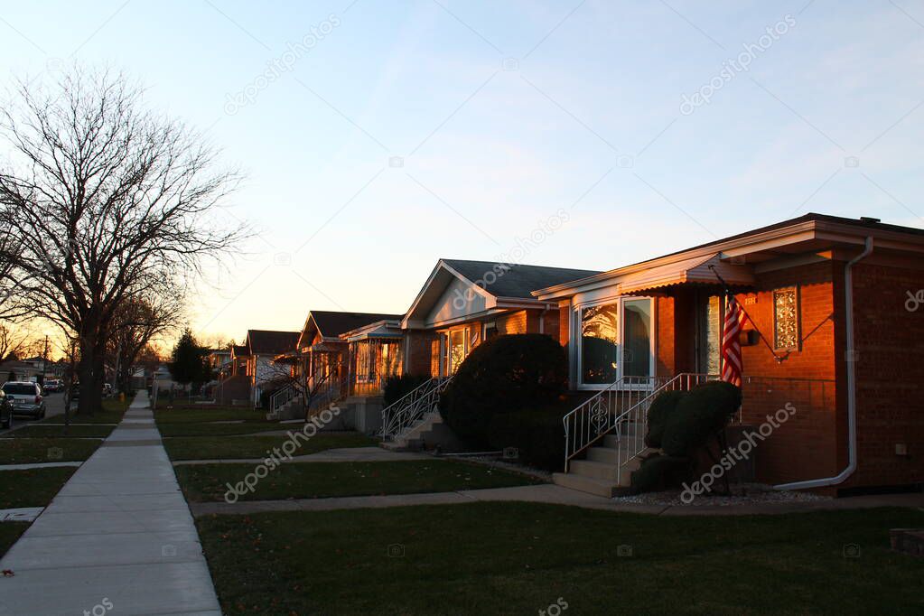 Row of houses in a Chicago suburban neighborhood at sunset with flag