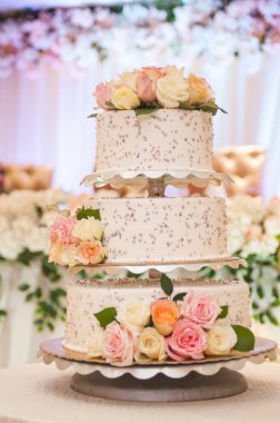 Çiğnenmiş güllerle süslenmiş düğün pastası.