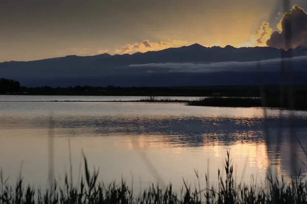 Kırgızistan 'da bir dağ gölünün üzerinde gün batımı