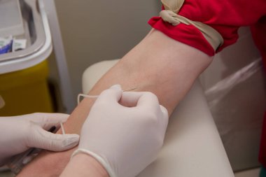 Doktor, analiz için bir sistem kullanarak hastanın damarından kan alıyor..