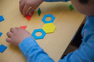 Çocuk yapbozdaki yüzü topluyor..