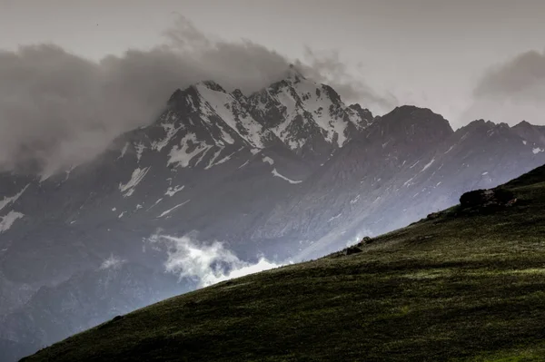Bulutların arasındaki karlı dağ zirveleri, Kırgız sırtı, Chonkurchak yolu, Kırgızistan. Seçici odak