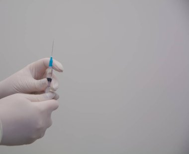 Doktor elinde ilaç olan bir şırınga tutuyor..