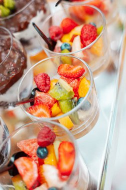 Böğürtlenli meyve salatası ve bir kaşık dolusu cam kase