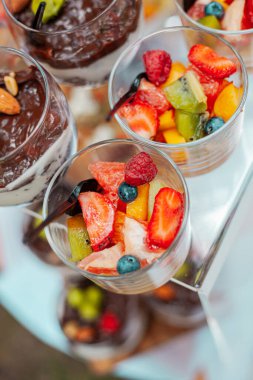 Böğürtlenli meyve salatası ve bir kaşık dolusu cam kase