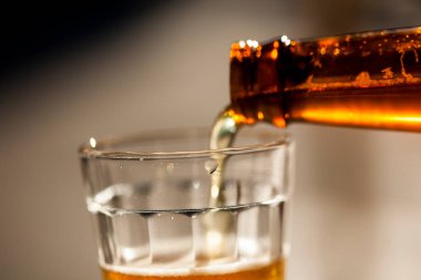 Güneşli bir günde şişeden cama bira dökülüyor. Yüksek kalite fotoğraf