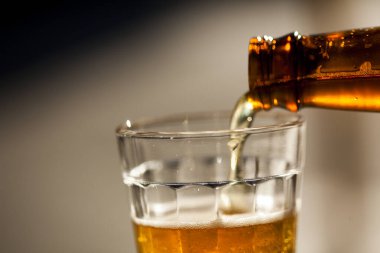 Güneşli bir günde şişeden cama bira dökülüyor. Yüksek kalite fotoğraf