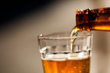 Güneşli bir günde şişeden cama bira dökülüyor. Yüksek kalite fotoğraf