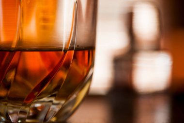 Viski bardağı karanlık bir bar ortamında kapanıyor. Bardağa odaklan. Boşluğu kopyala. Yüksek kalite fotoğraf