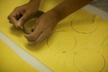 İnsan elleri mutfak masasında çiğ ve kuru kapeletti makarnası yapıyor.