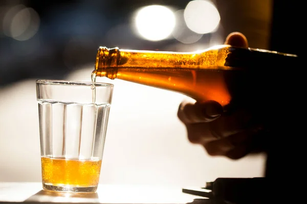 Güneşli bir günde şişeden cama bira dökülüyor. Yüksek kalite fotoğraf