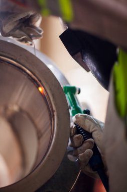 İnsan kaynak yapmak için elektrikli kaynak makinesi kullanarak metal kaynaklama çeliği üzerinde çalışır..