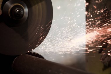 Kıvılcımlar, iğne işleme makinesinde uçuşuyor. Metalürjik bitki arka planı. Endüstriyel üretim kavramı için bitmiş parçalar üretimi. 