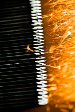 Kıvılcımlar, iğne işleme makinesinde uçuşuyor. Metalürjik bitki arka planı. Endüstriyel üretim kavramı için bitmiş parçalar üretimi. 