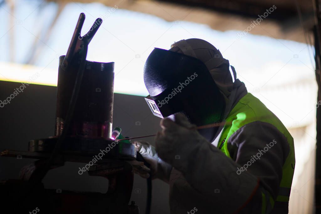 Man works on metal welding steel using electric welding machine to weld.
