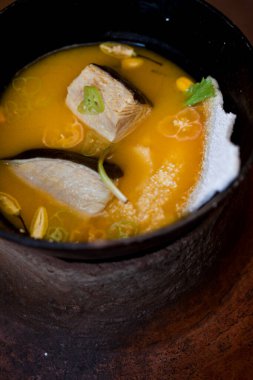 Amazonian cuisine. Green ingredients, manioc soup on a wooden table set. High quality photo