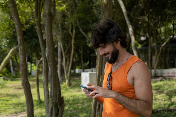 Jongeman Een Park Een Mooie Zonnige Dag Met Mobiele Telefoon — Stockfoto