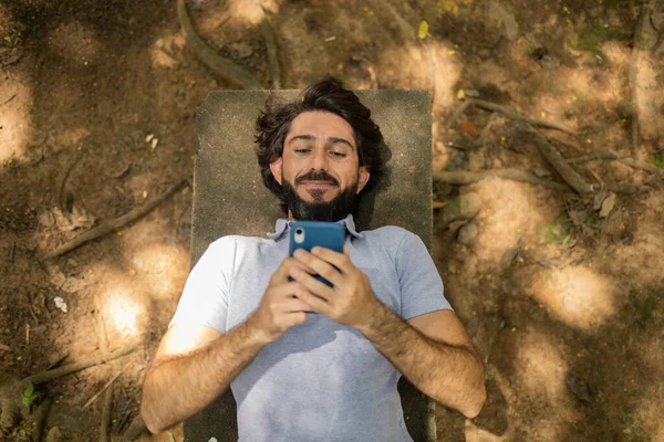 Vista Jovem Usando Smartphone Dia Deitado Banco Parque Foto Alta — Fotografia de Stock