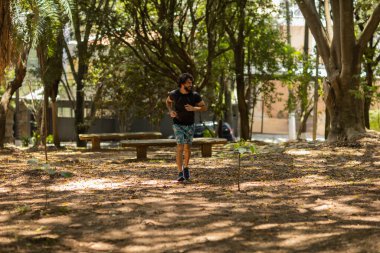 Genç bir adam parkta koşuyor ve koşuyor. Spor yaparken sporcu erkek. İyi, sağlıklı bir konsept. Yüksek kalite fotoğraf