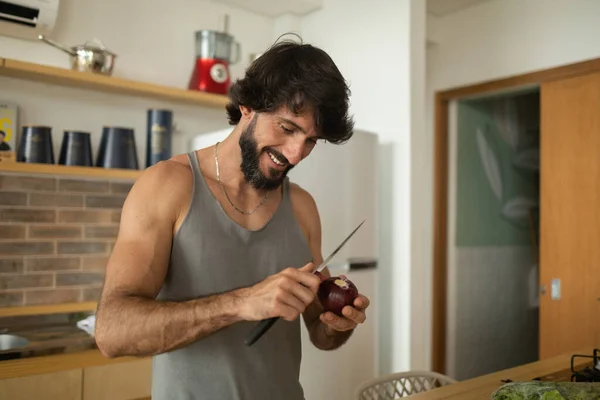 Mutfakta vejetaryen yemeği hazırlayan mutlu ve sağlıklı genç adam yemeği. Yüksek kalite fotoğraf. İyi, sağlıklı ve sağlıklı hissediyorum.. 